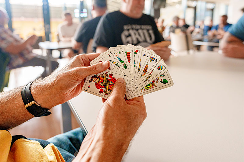 Dynamofan hält Skatkarten in der Hand